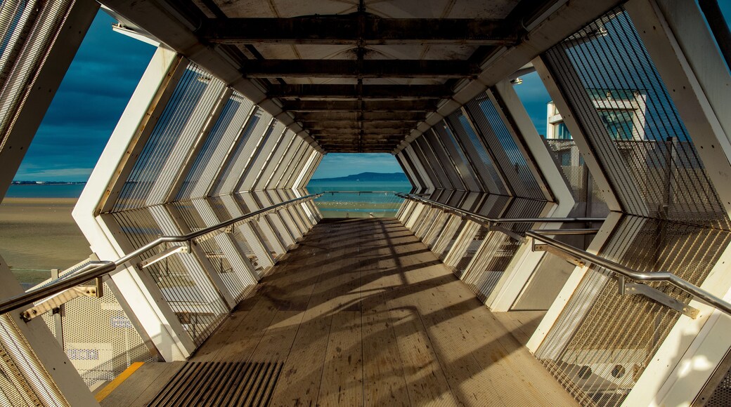 Modern polygon-shaped peatonal bridge in an Irish train station with a view at the beach.Booterstown dart station, Dublin, Ireland.