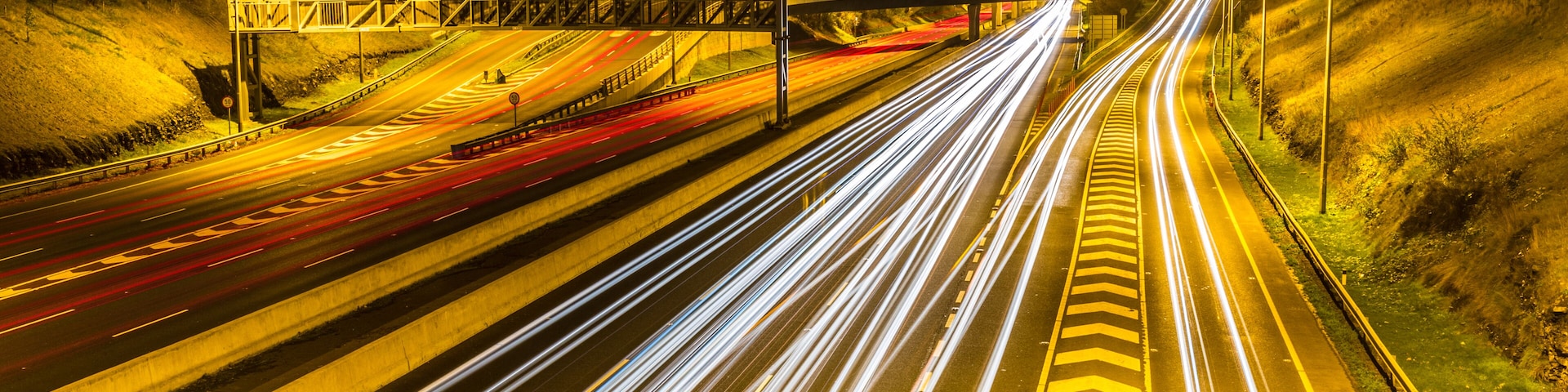 A multi-lane highway at night with light trails from moving vehicles.