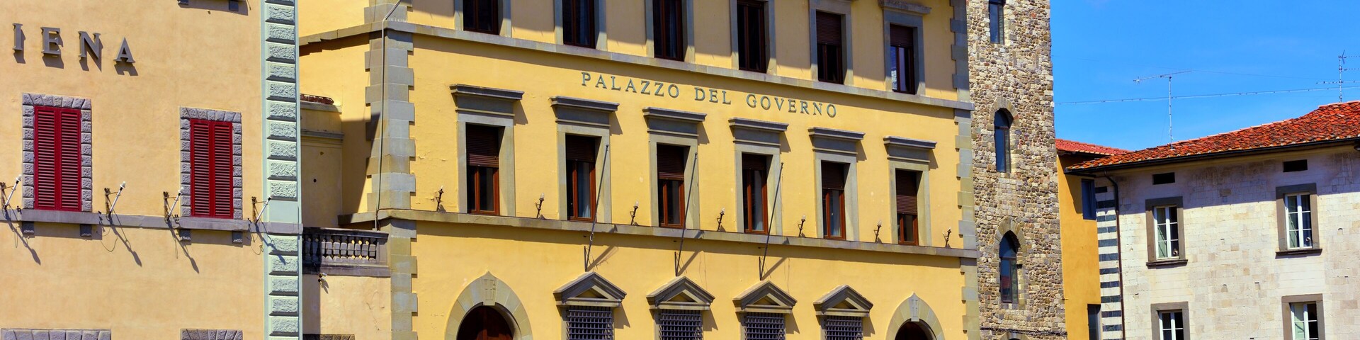 Un edificio histórico con la inscripción 'Palazzo del Governo', y un ciclista en primer plano.