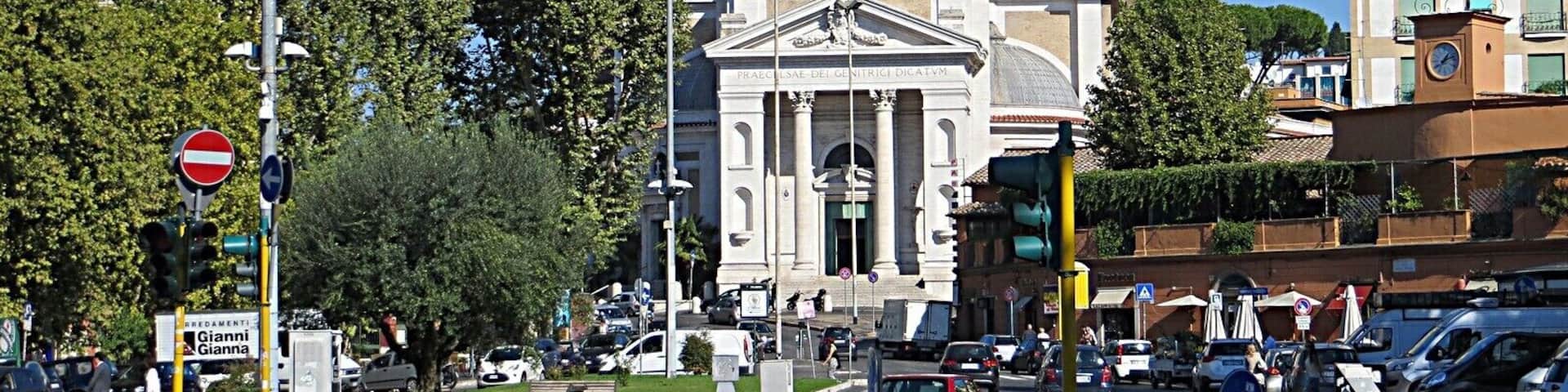 A city intersection with a prominent historical building featuring a large dome and bell towers.