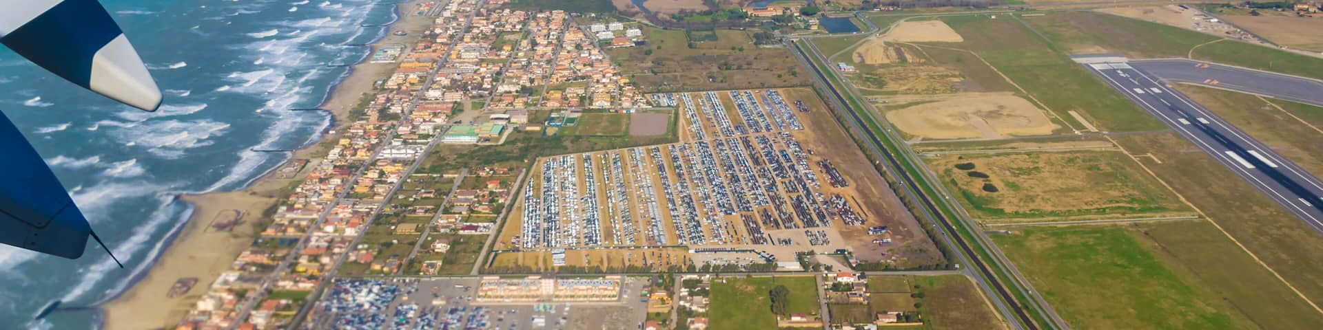 Looking through window aircraft at wing of airplane flying over the fiumicino where is situated the Fiumicino International Airport "Leonardo da Vinci.
