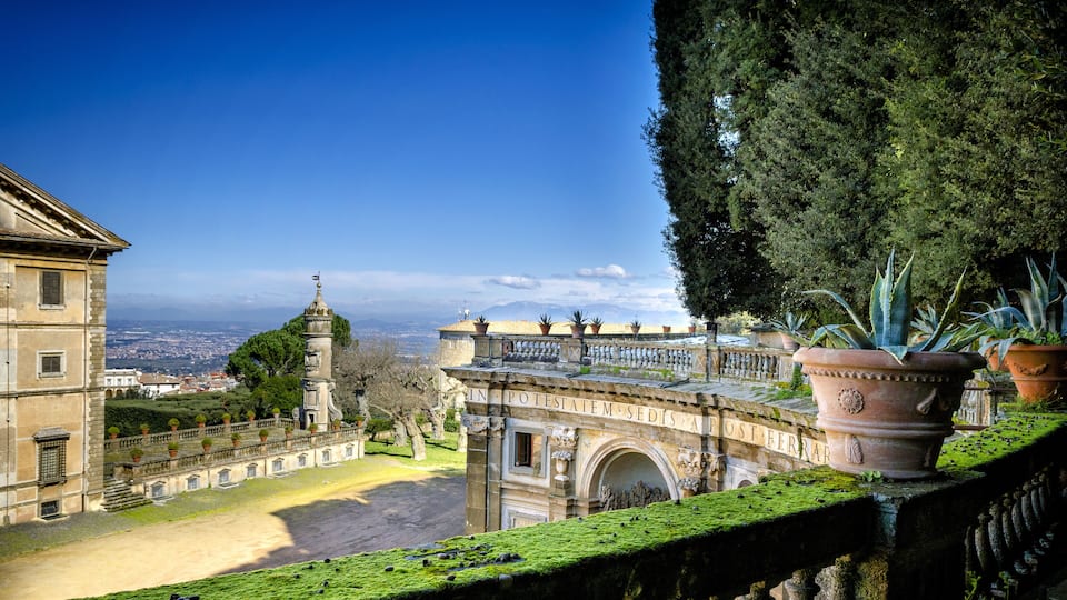 A historic building with a view of the city and mountains in the background.