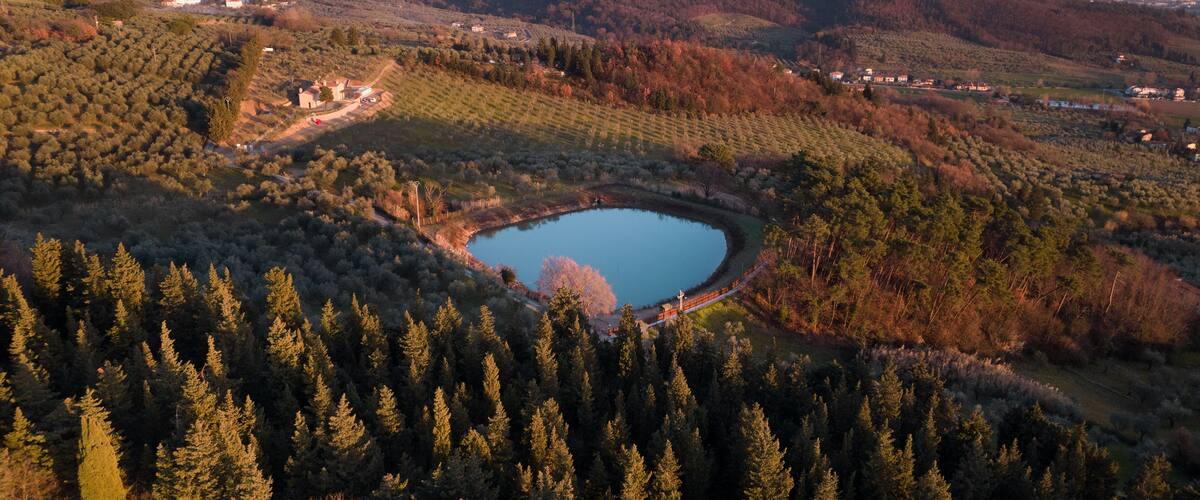 A lake surrounded by dense forests and rolling hills.