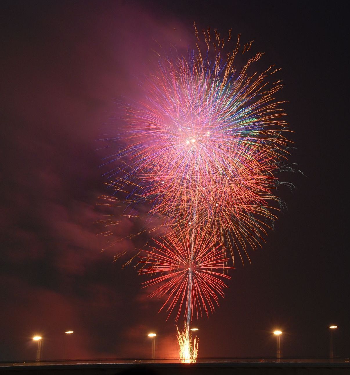 Céu noturno com um grande e colorido espetáculo de fogos de artifício.