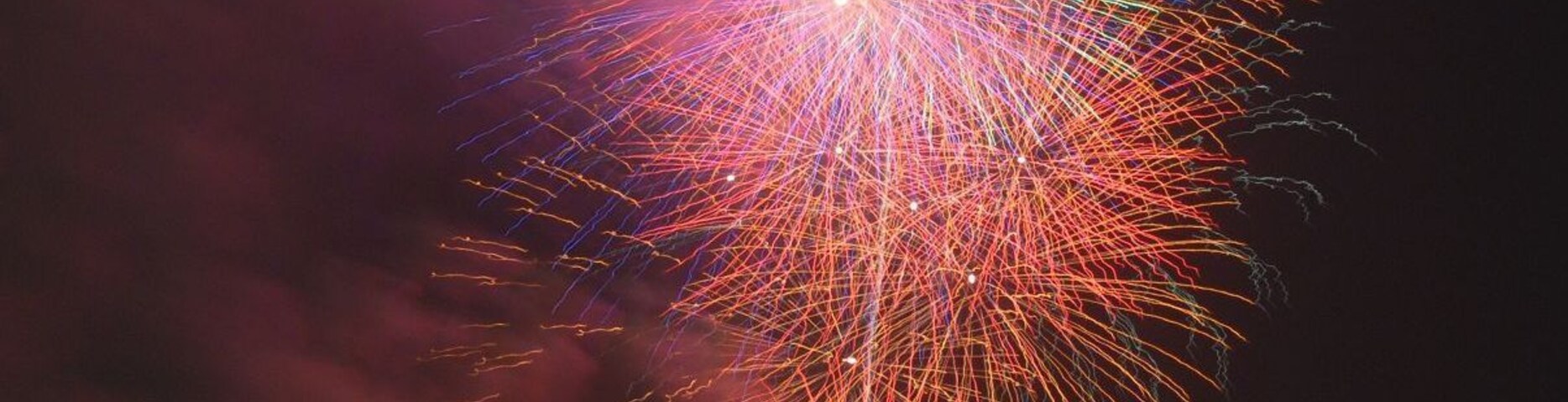 Céu noturno com um grande e colorido espetáculo de fogos de artifício.