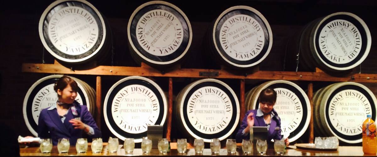 A distillery with large barrels labeled "Whisky Distillery" and "Pot Still Whisky" on display.