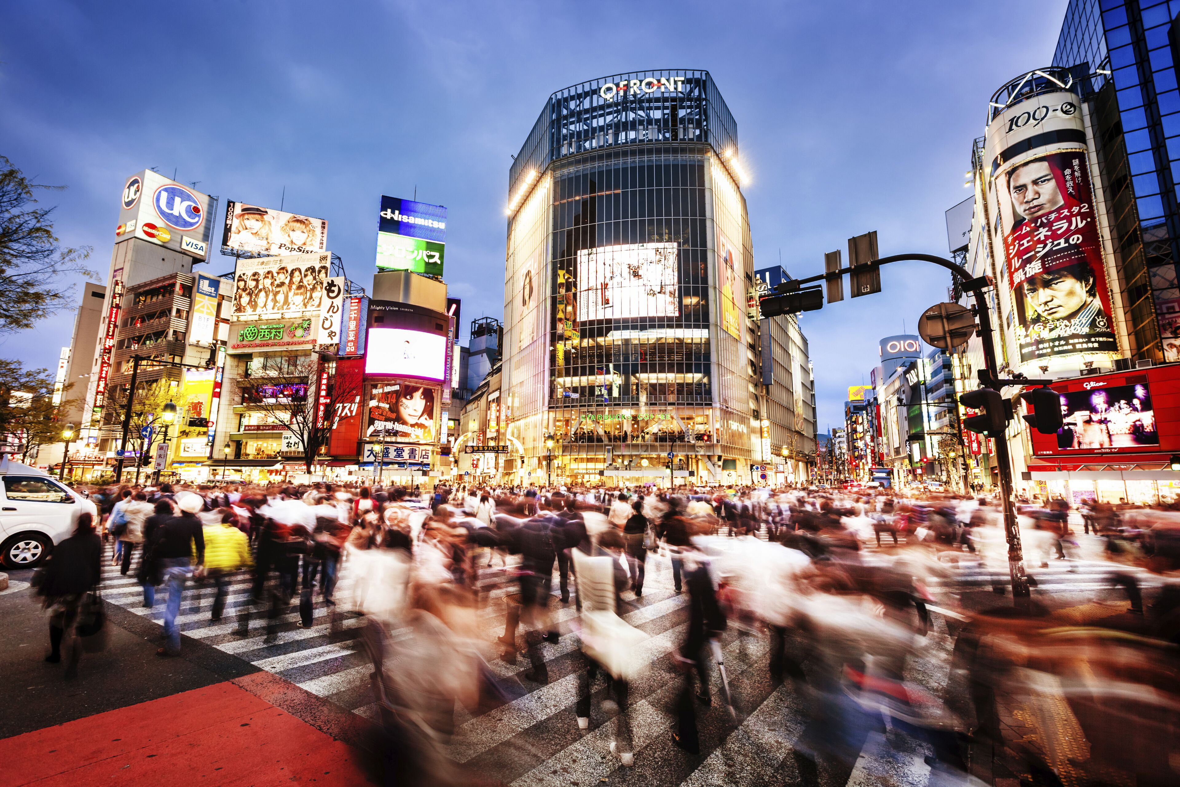 The world famous crossroad in Shibuya, Tokyo with commuters at dusk