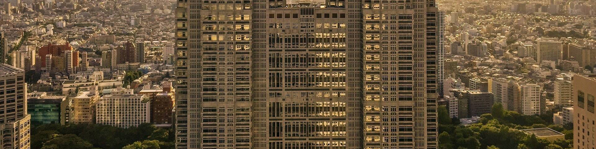 Two tall buildings with a dense urban background.