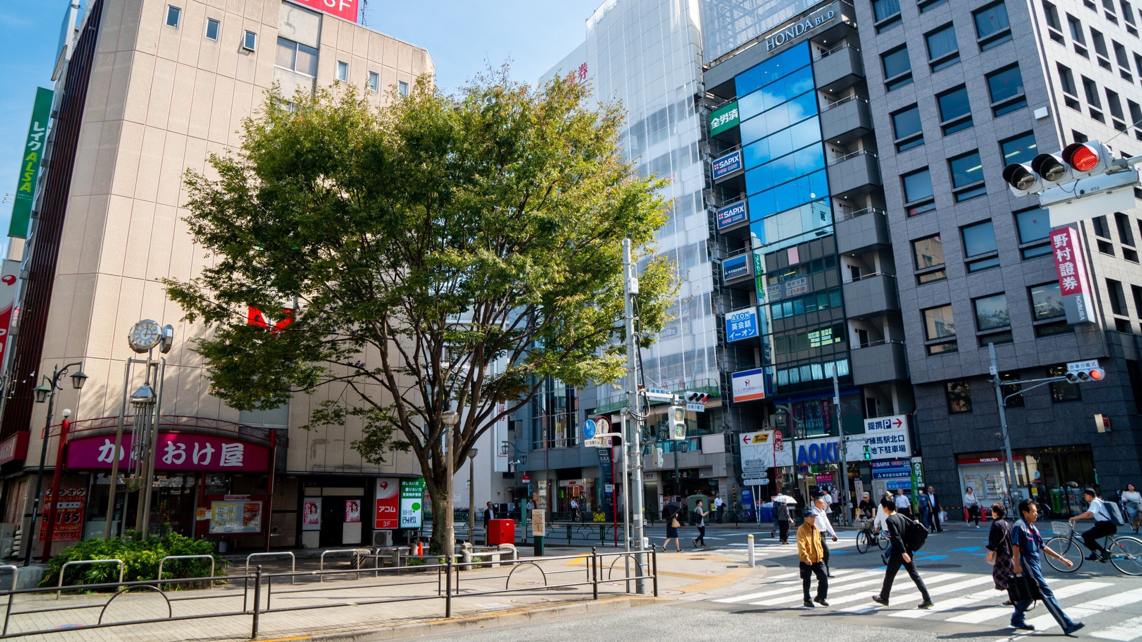 A busy urban street with pedestrians, cyclists, and tall buildings.