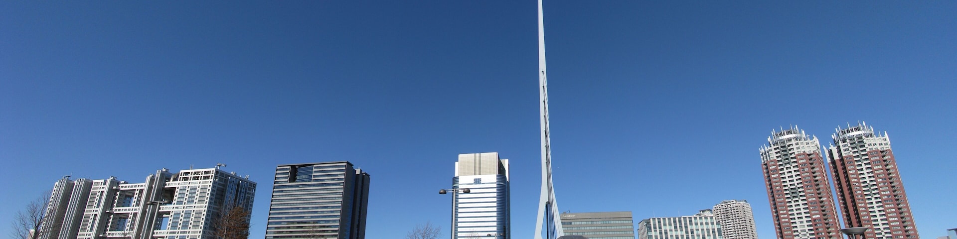 Linha do horizonte urbana com edifícios modernos e uma torre singular.