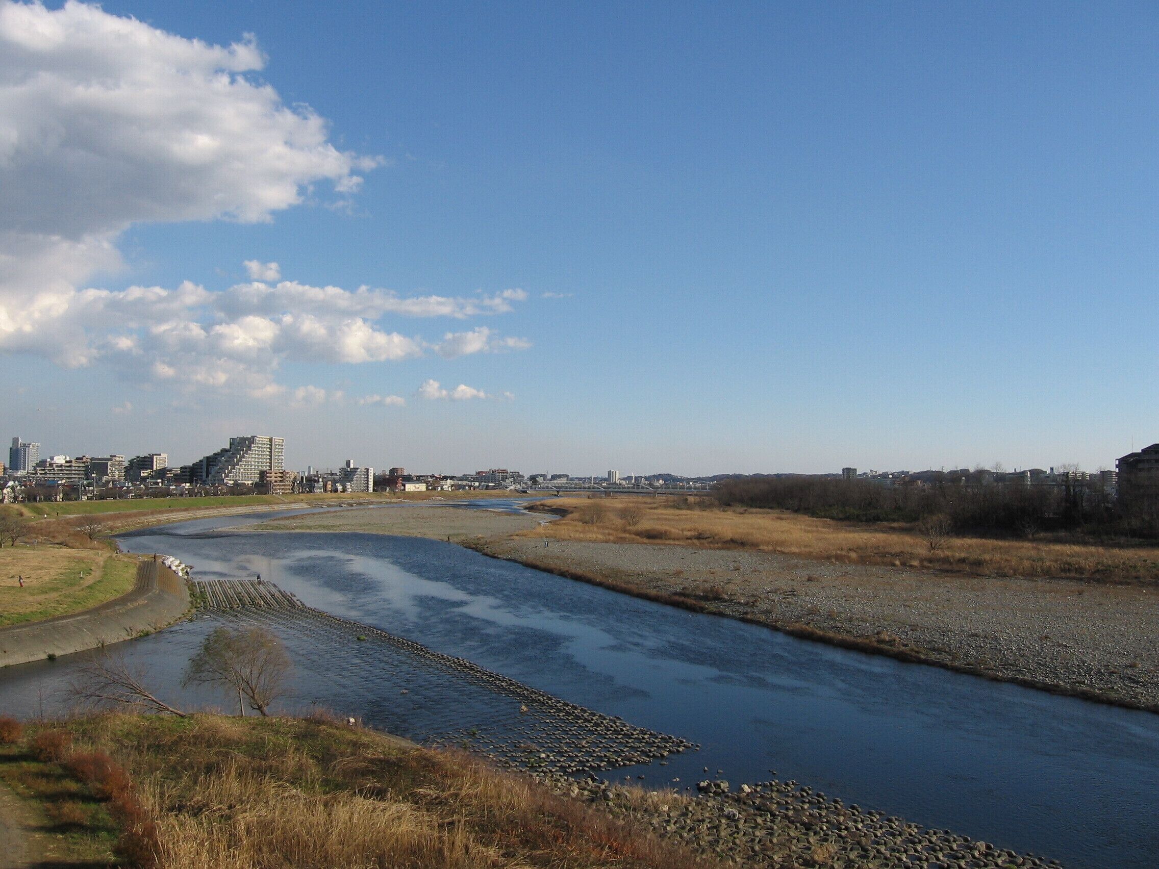 A river meandering through a cityscape with buildings in the background.