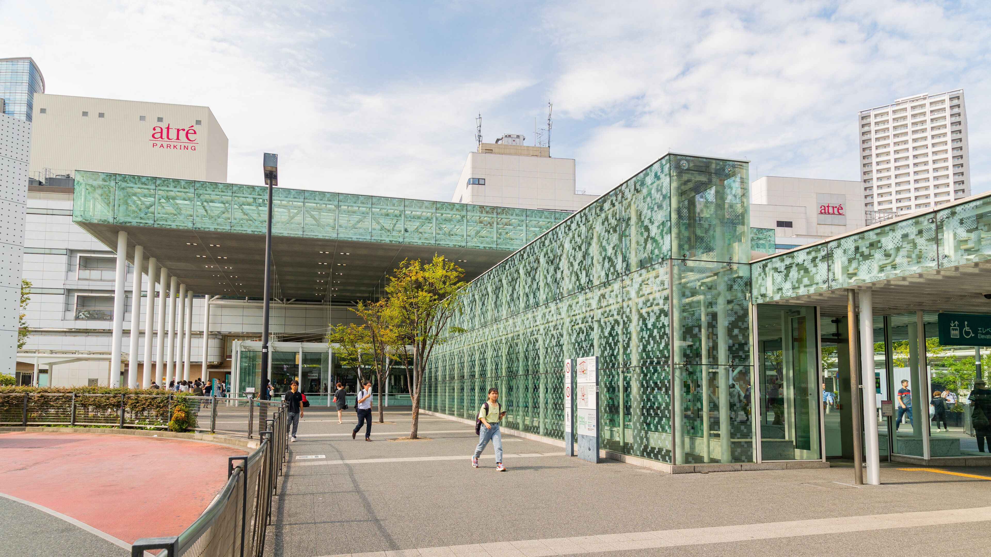 A modern building with a glass facade and a green patterned exterior.