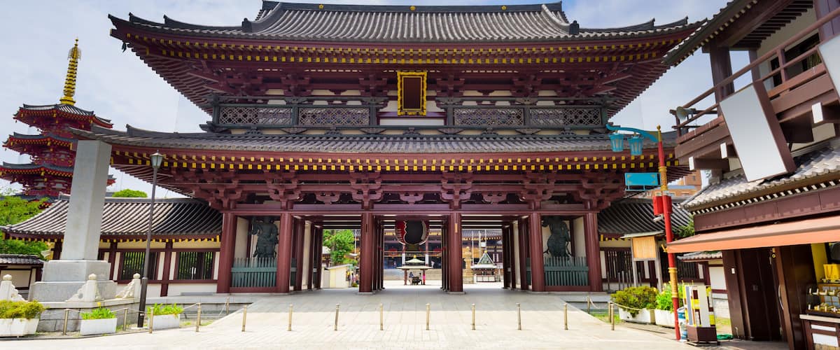 A traditional multi-tiered pagoda with ornate roof tiles and a central statue.