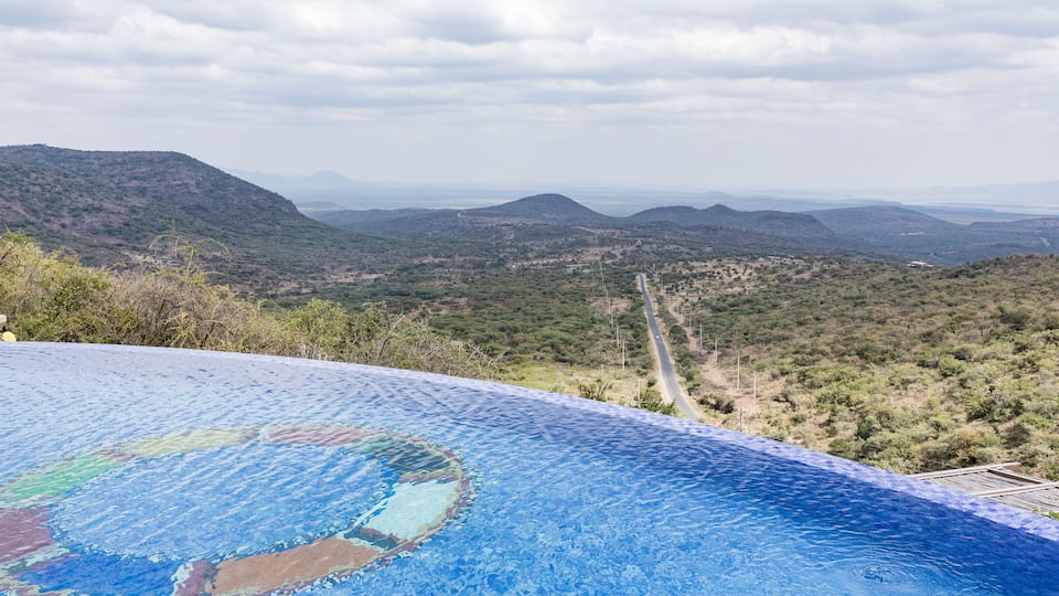 A swimming pool with a view of a mountainous landscape.