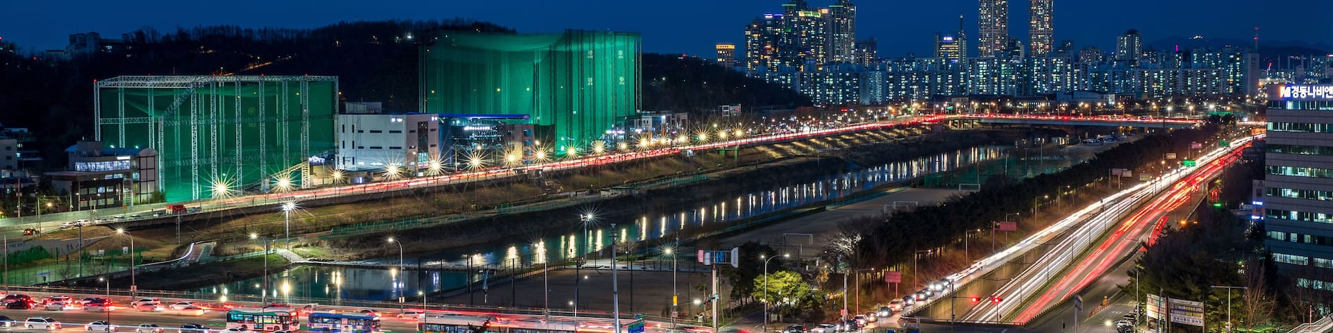 A nighttime cityscape with multiple highways and a bridge.