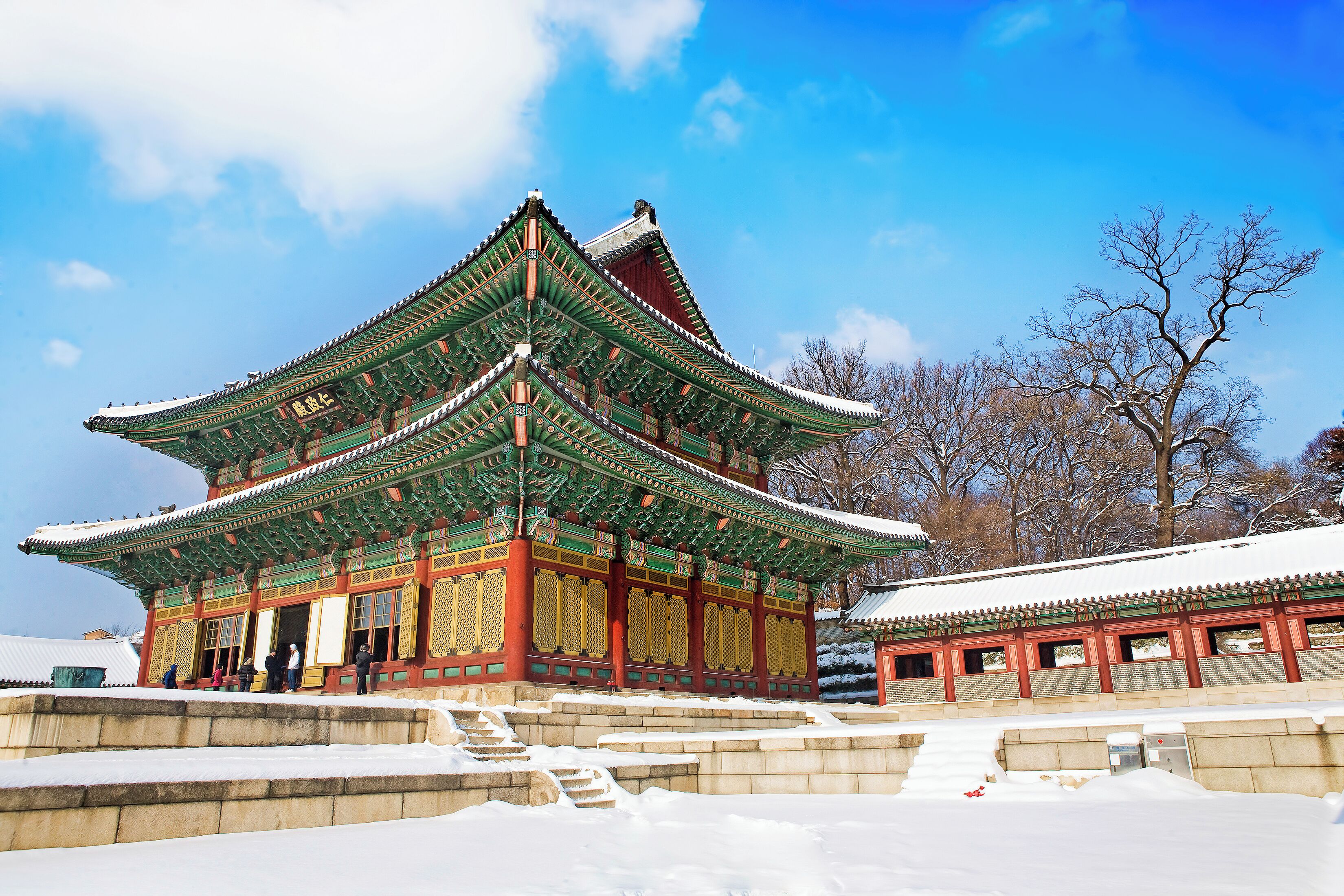 Um palácio coreano tradicional com arquitetura elaborada e paisagem coberta de neve.