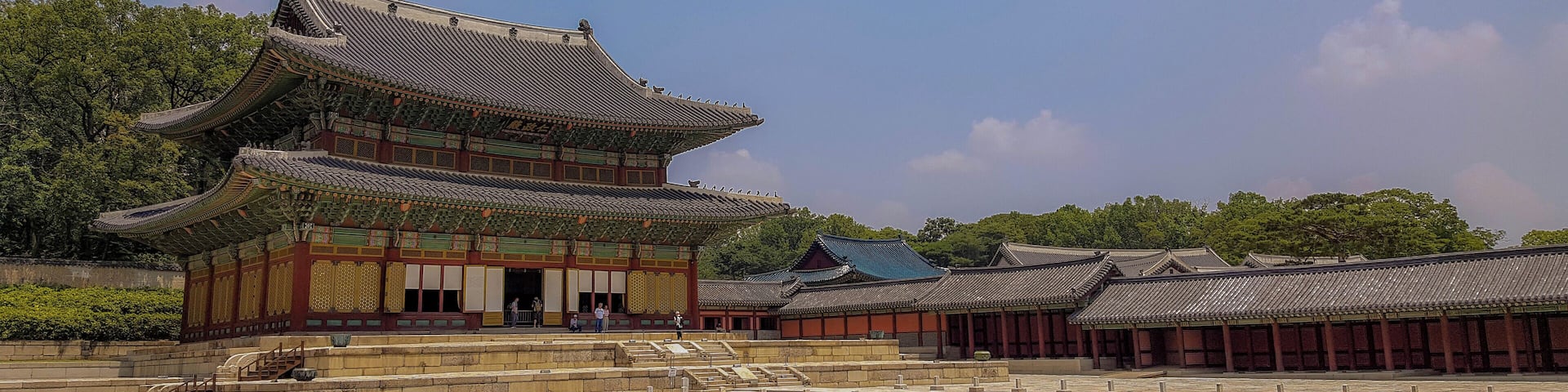 A traditional Korean palace with a multi-tiered roof and a spacious courtyard.