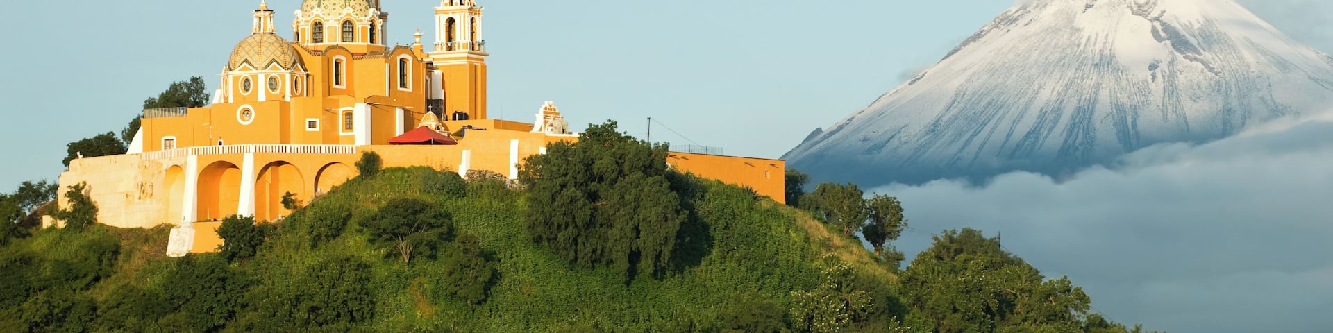 View of Popocatepetl volcano, with the church of Nuestra Señora de los Remedios at the front. City of Cholula, Mexico.