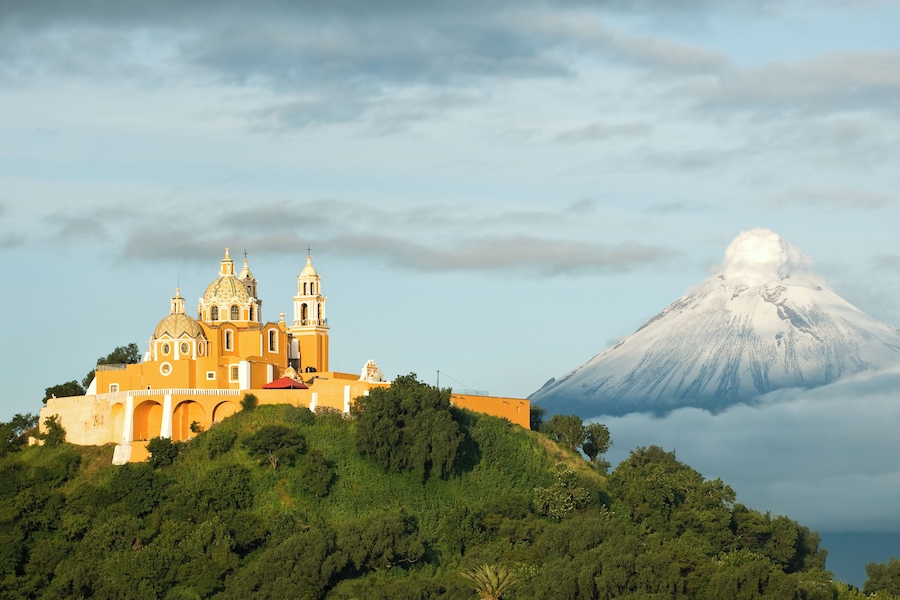 View of Popocatepetl volcano, with the church of Nuestra Señora de los Remedios at the front. City of Cholula, Mexico.
