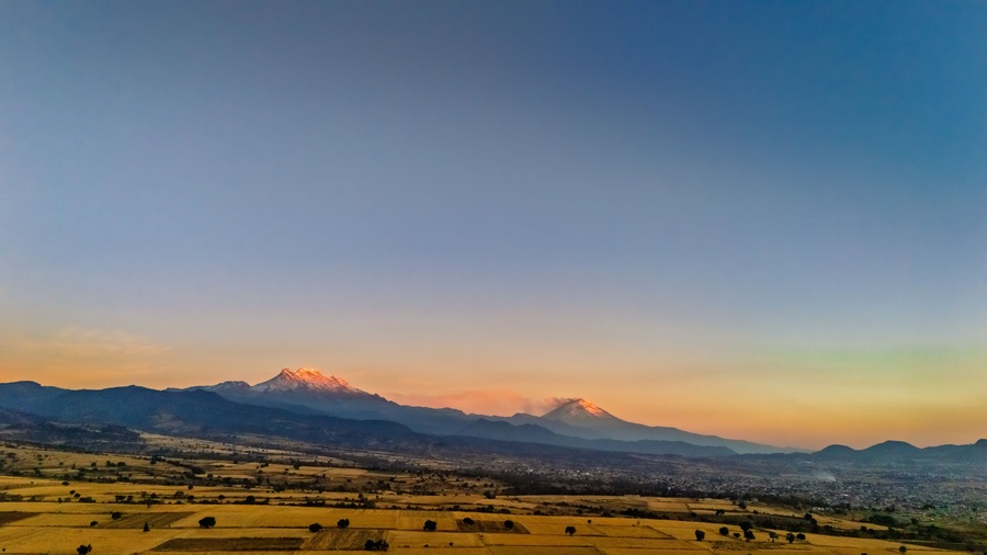 Aerial view of Popocatepetl and Iztaccihuatl volcanoes at sunset near Ixtapaluca, Mexico