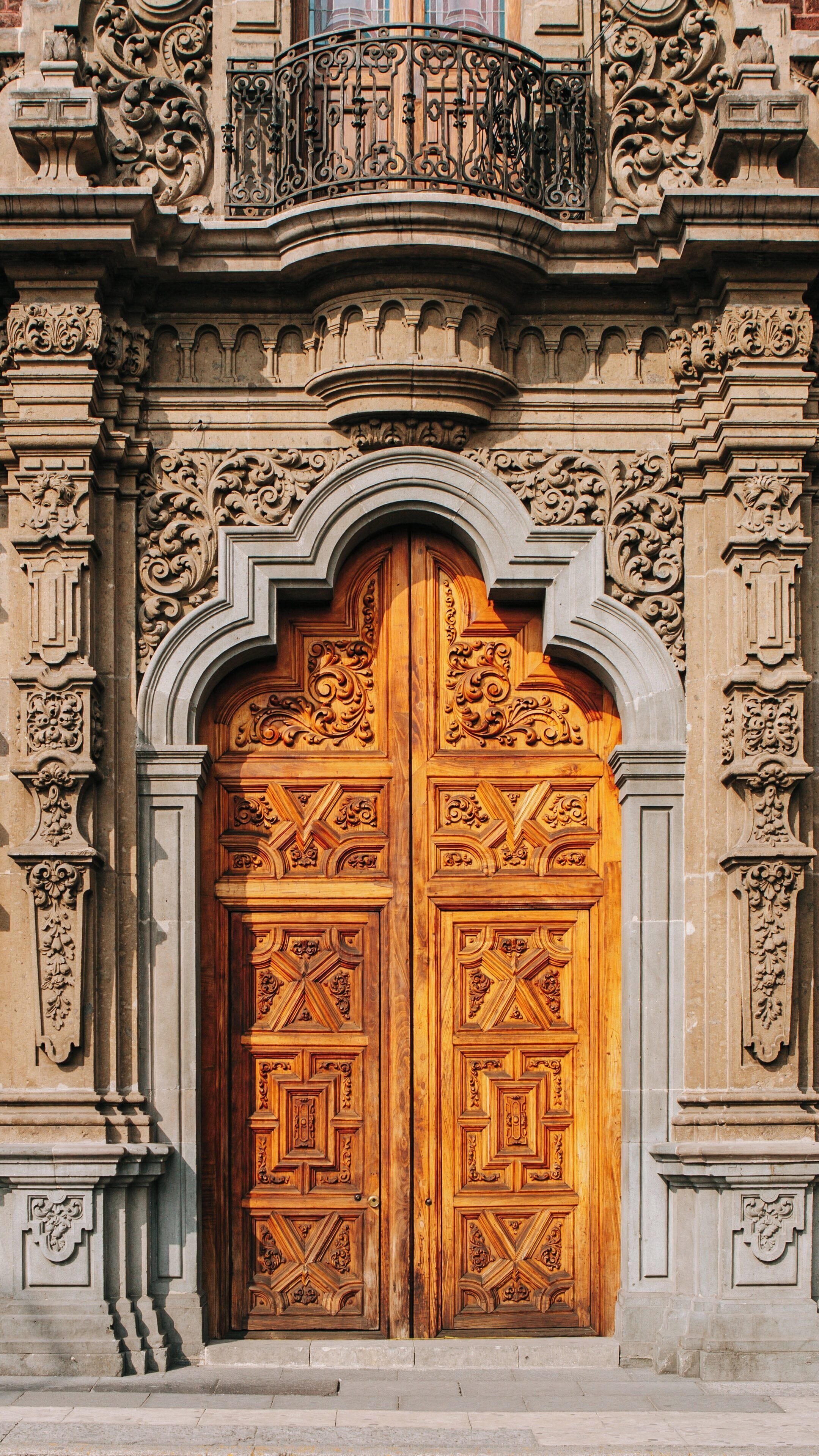 Ornate wooden doors of San Ildefonso College showcase intricate craftsmanship in Cuauhtémoc, Mexico City, capturing historical architecture