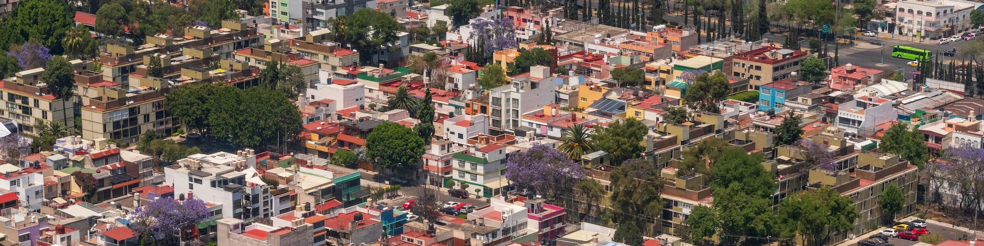 A densely packed urban area with a mix of residential and commercial buildings, including a prominent multi-story structure with a red roof.