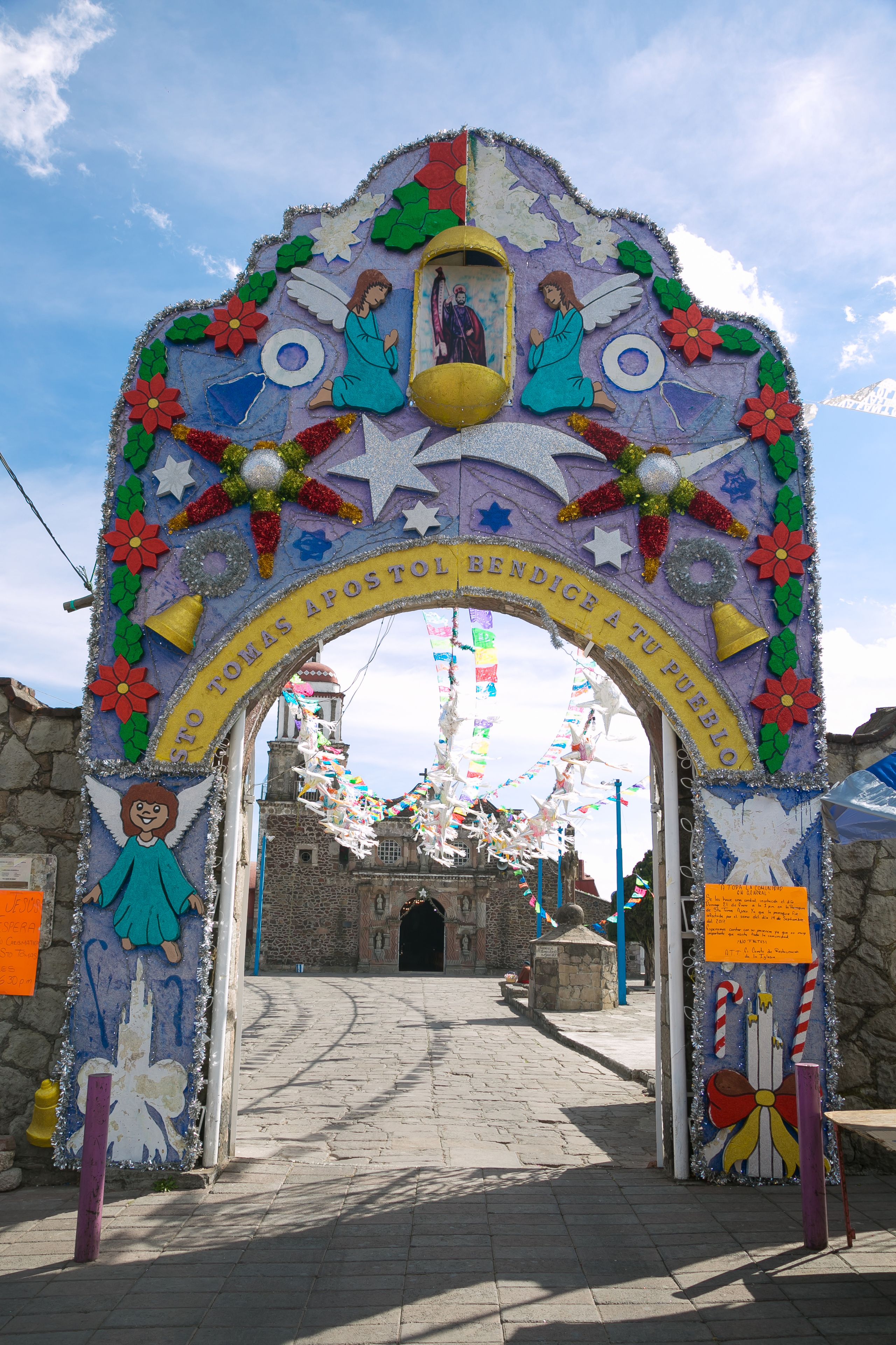Un arco colorido con figuras religiosas y adornos, que conduce a una iglesia.