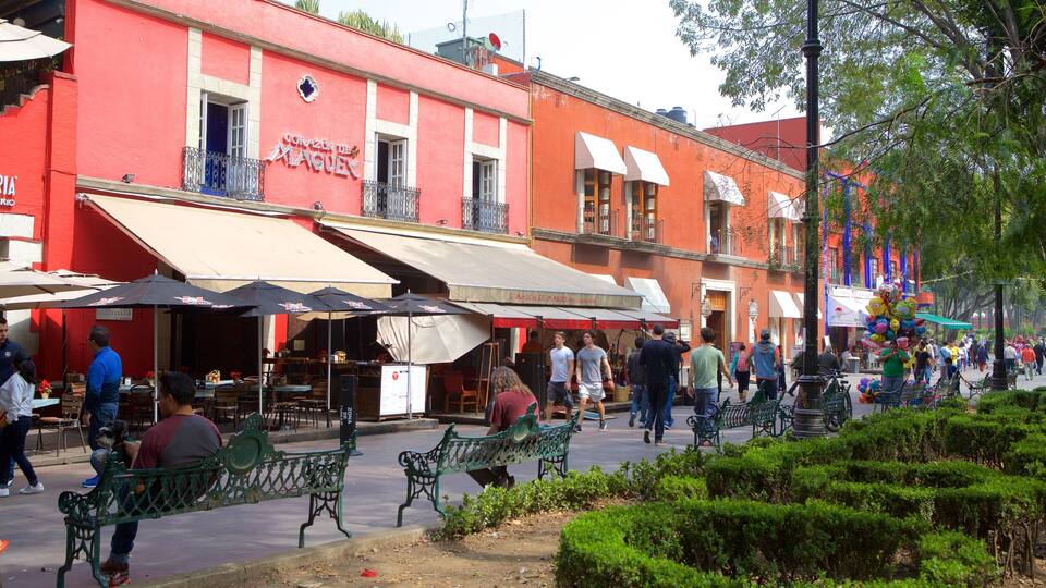 A bustling street with outdoor seating at a restaurant named "Cofazón de Maque."