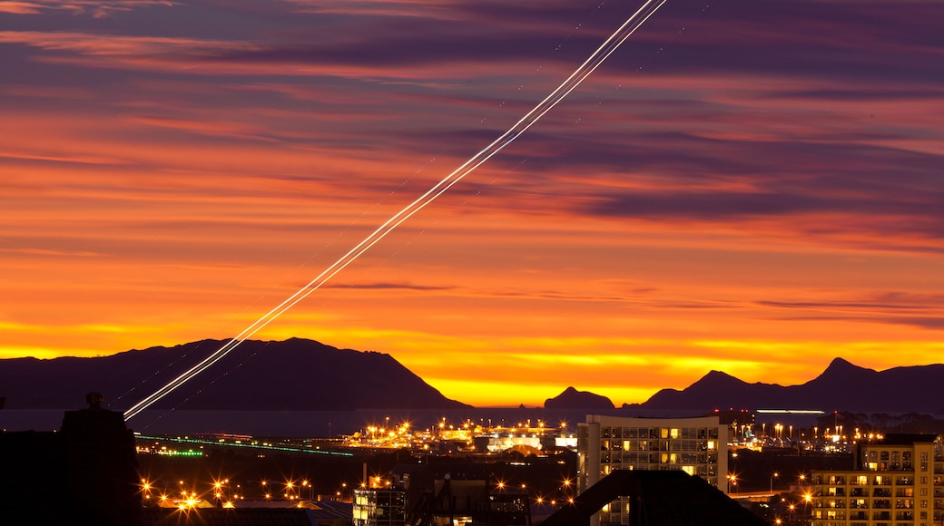 A sunset with a cityscape and mountains in the background.