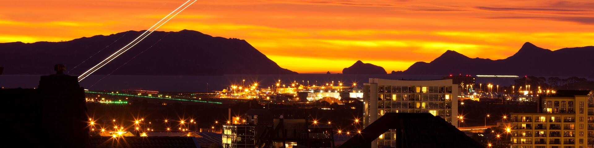 A sunset with a cityscape and mountains in the background.