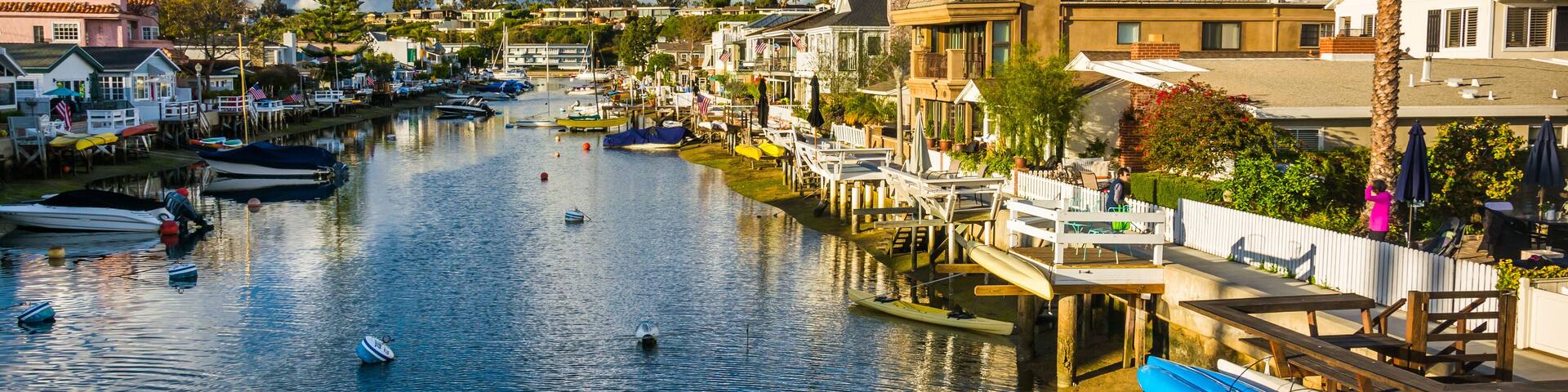 A river with boats, a dock, and buildings along the shore.