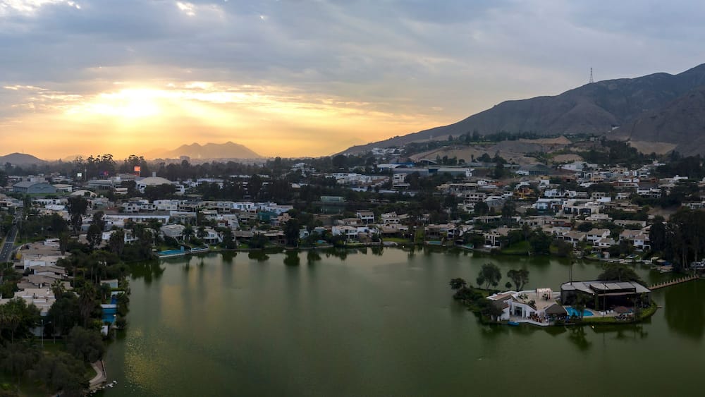 Lima, Perú - May 4 2019: Panoramic aerial view of Las Lagunas in La Planicie. Lake at sunset with houses of high class.