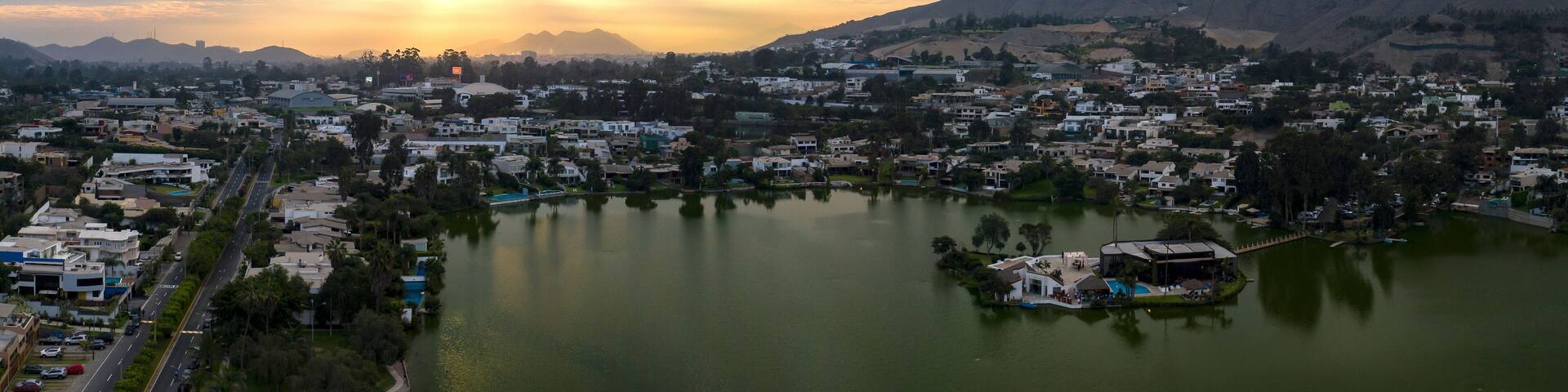 Lima, Perú - May 4 2019: Panoramic aerial view of Las Lagunas in La Planicie. Lake at sunset with houses of high class.