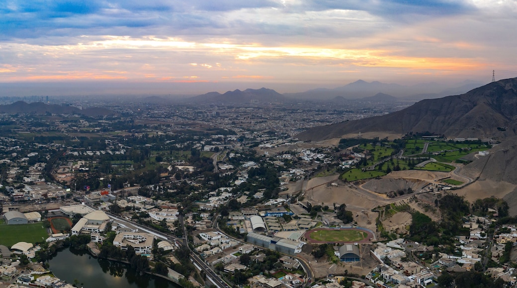 Lima, Perú - May 4 2019: Panoramic aerial view of La Molina district in La Planicie urbanization. Cityscape with lake at sunset. Urban panorama in Lima city.
