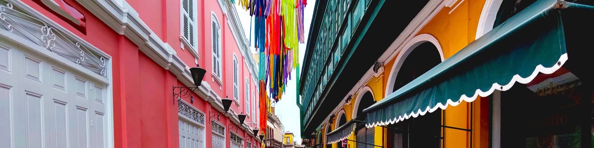 A colorful street with patterned pavement, vibrant buildings, and hanging decorations.