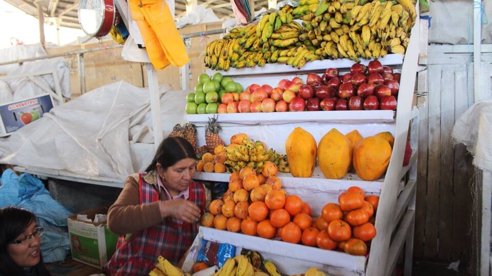 Ein Obststand mit Bananen, Äpfeln, Orangen und anderem Obst.