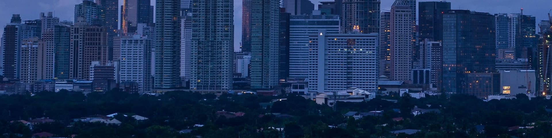 Makati, Metro Manila, Philippines: Afternoon Skyline with pink dramatic sky and clouds and Dasmarinas Village.
