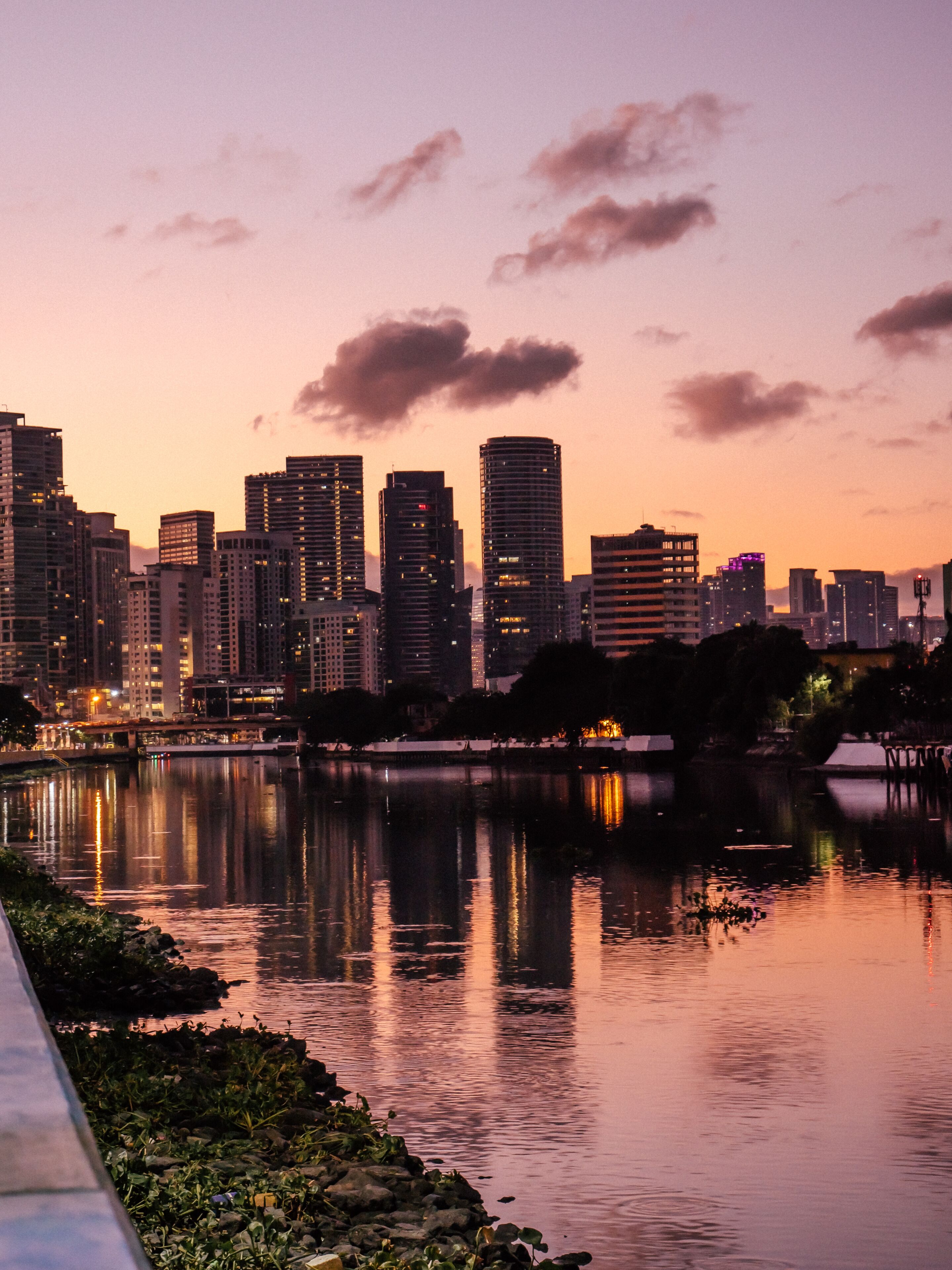 Skyline of Makati City reflecting in the Pasig River in Metro Manila, Philippines while sunrise