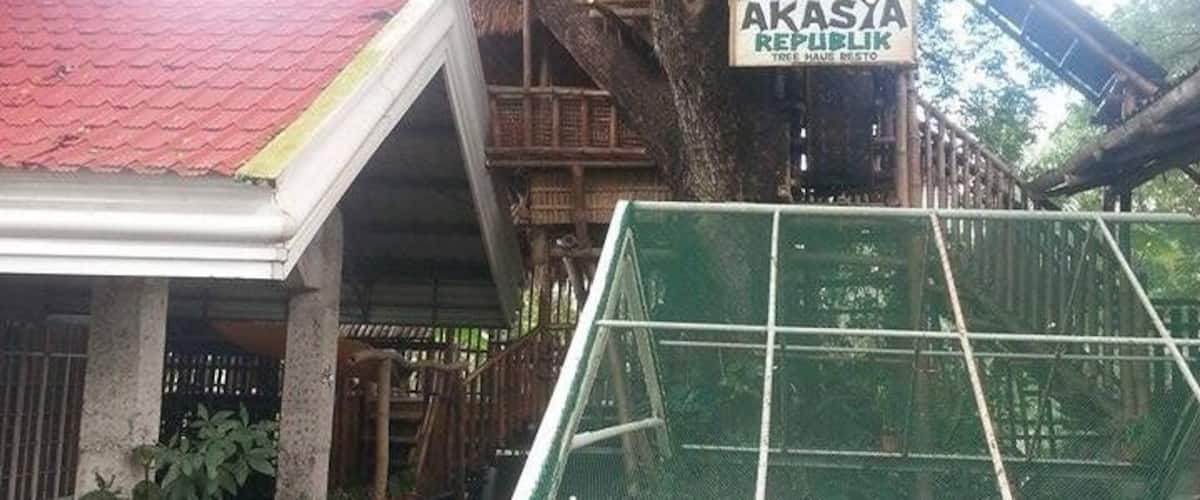 A treehouse with a sign reading "AKASYA REPUBLIC TREE HOUSE RISTO".
