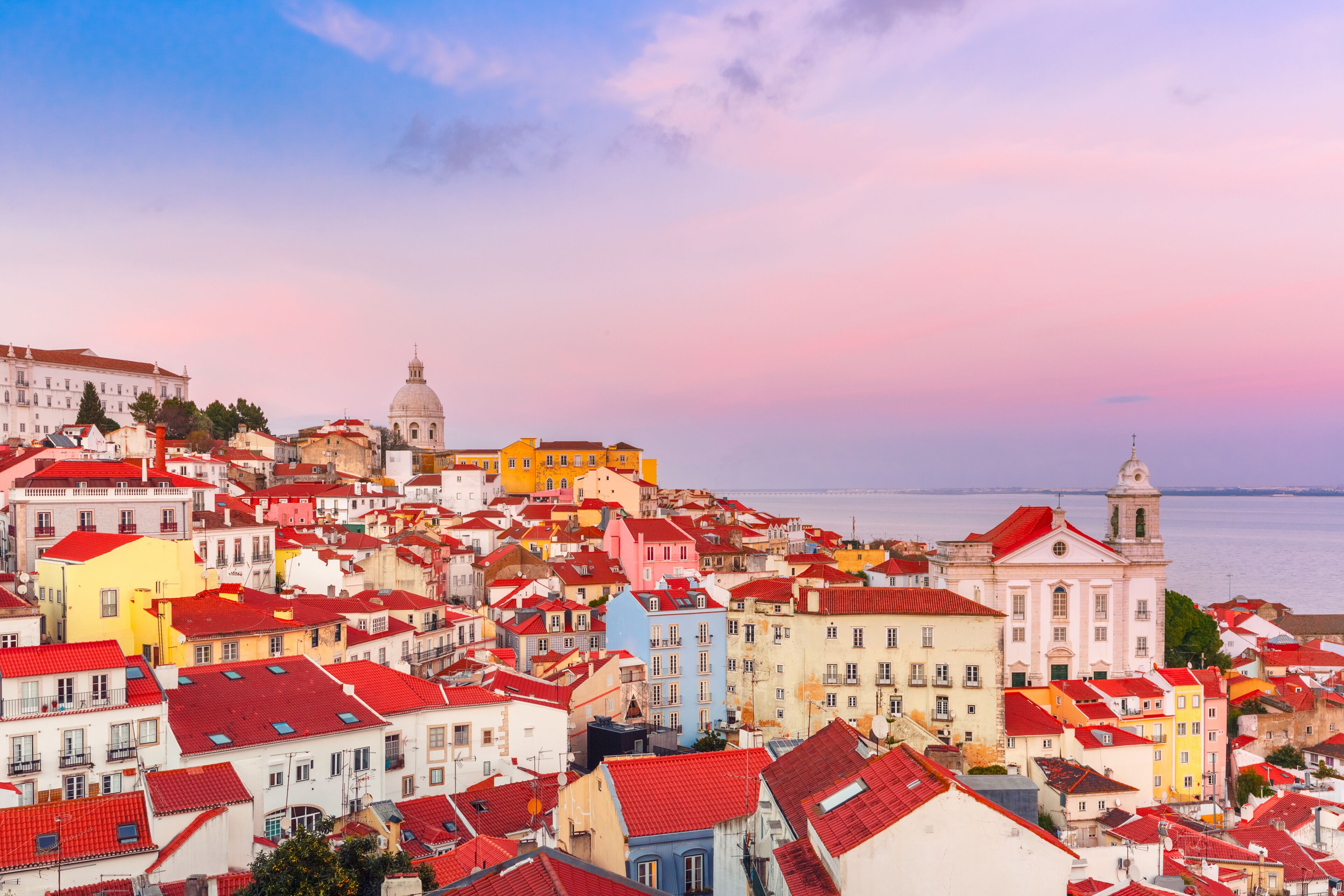 A coastal cityscape with colorful buildings and a prominent church.