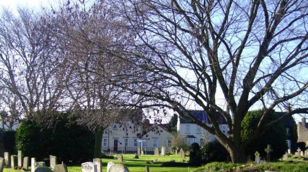 Great Wakering: St Nicholas' churchyard, Essex Taken standing in St Nicholas' churchyard on Great Wakering Common. You can clearly see many of the interesting and ancient graves in the foreground, plus the old cottages of New Road behind the churchyard. This area was once a bakery. The following is a picture I recently found of this area depicting old baker's shop on the junction of New Road and Shoebury Road. http://www.peter-owen.myby.co.uk/postcards/greatwakering/gtwk05.jpg