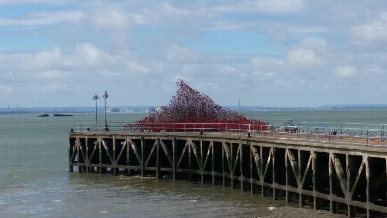 A pier with a large red sculpture in the middle.
