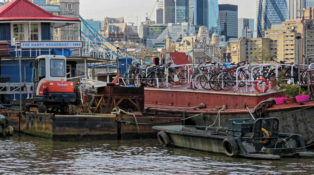 Boats moored off New Concordia Wharf looking northwest towards the City of London from the Thames Path in Bermondsey, Southwark, London, England. Camera: Canon PowerShot SX60 HS. Software: file lens-corrected and optimized with DxO PhotoLab Elite and Viewpoint 3, and further optimized with Adobe Photoshop CS2.