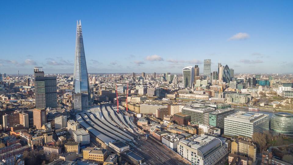 A cityscape with the Shard, a distinctive skyscraper, and a complex railway system.