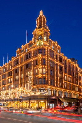 A grand, illuminated building with ornate architecture and a prominent sign reading 'CHRISTIAN DIOR.'