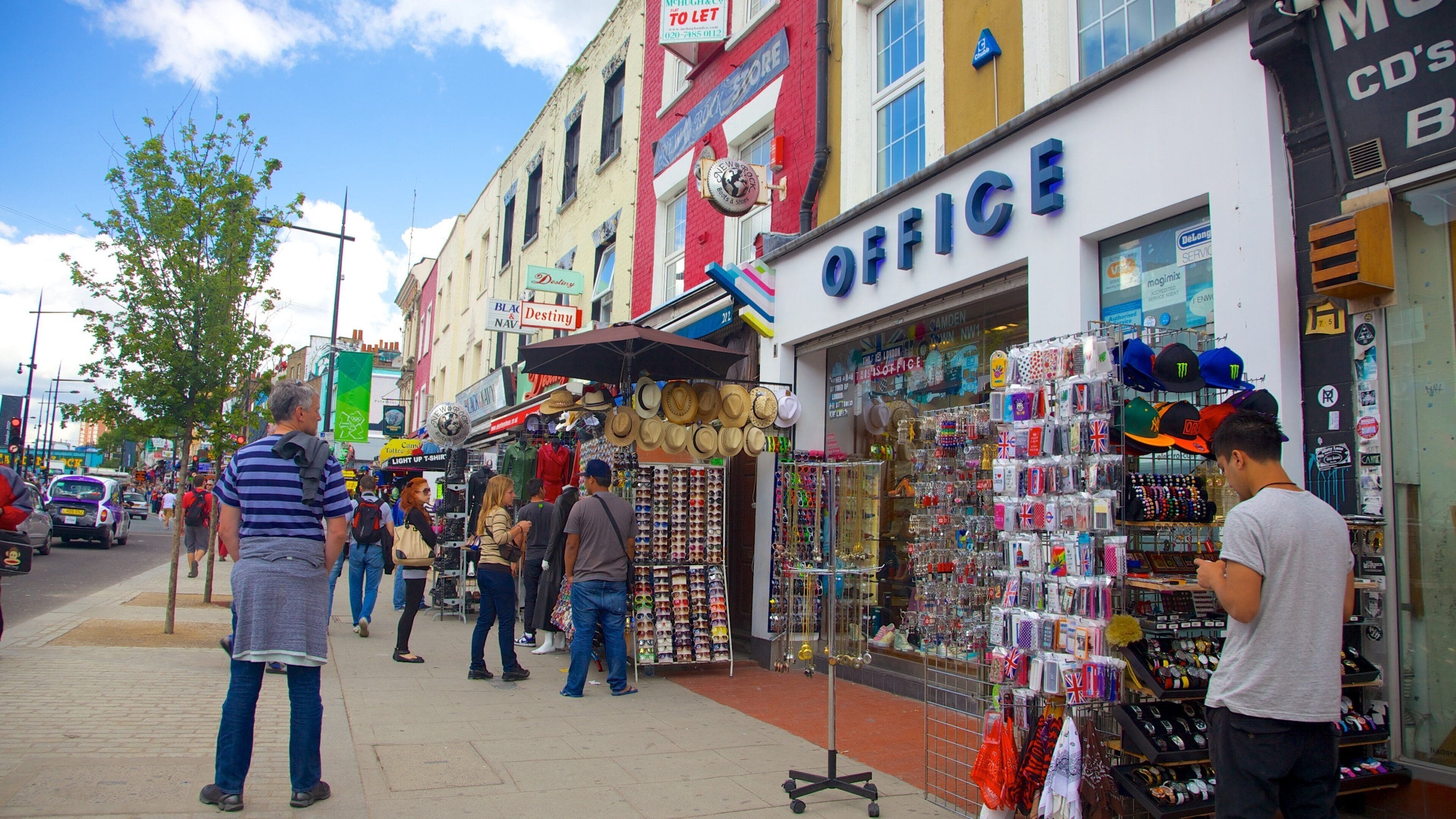 A busy street with shops, including a hat store and an office.