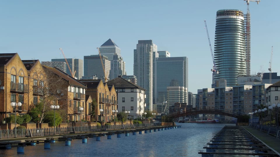 A river with a bridge, historic buildings, and modern skyscrapers.
