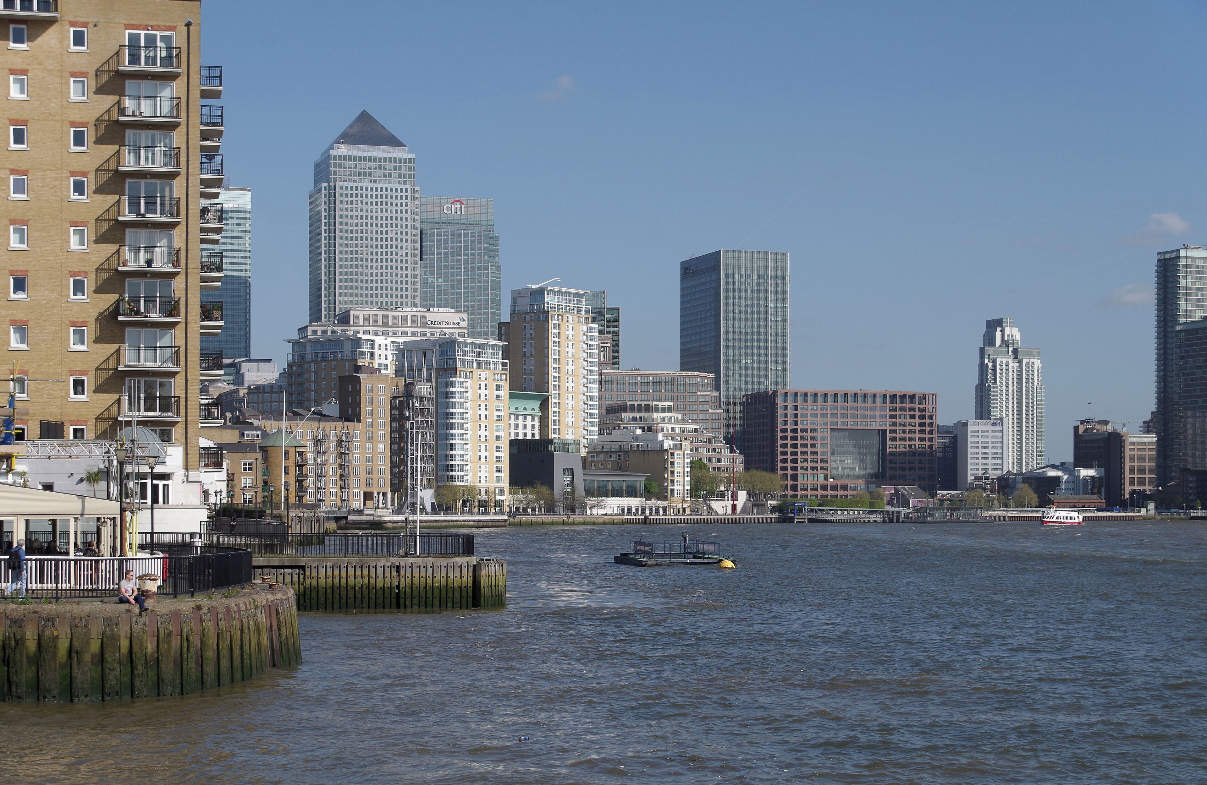 A city skyline with modern buildings and a river.