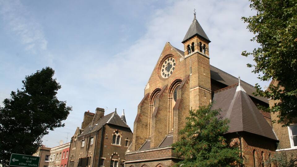 A historic church with a prominent clock tower and arched windows.