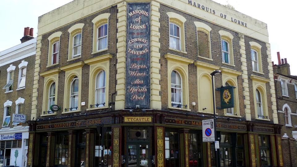 A corner building with a marquee sign advertising beers, wines, ales, spirits, and pool.